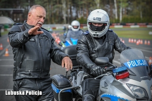 policjant ćwiczy jazdę motocyklem na torze pod okiem instruktora
