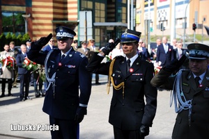 Komendanci służb mundurowych oddają honory przed pomnikiem.