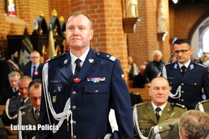Komendant Wojewódzki Policji stoi w kościele.