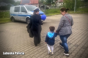 chłopiec z kobietami spaceruje po terenie komendy Policji