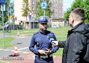 Policjant drogówki udziela wywiadu w &quot;miasteczku ruchu drogowego&quot;.