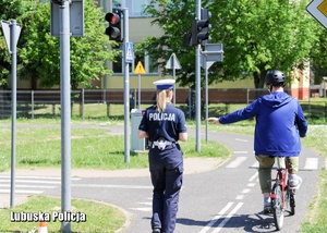 Policjantka z rowerzystą na drodze.