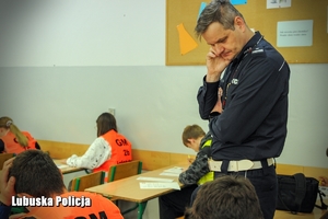 policjant obserwuje uczniów w klasie