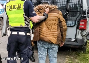 policjant prowadzi zatrzymanego mężczyznę