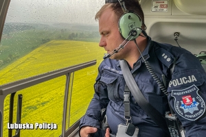 policjant obserwuje teren z helikoptera