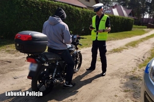 policjant kontroluje motocyklistę