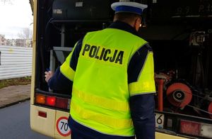 Policjant sprawdza stan techniczny autokaru
