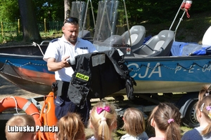 policyjny wodniak rozmawia z dziećmi i uczy je zasad bezpieczeństwa nad wodą