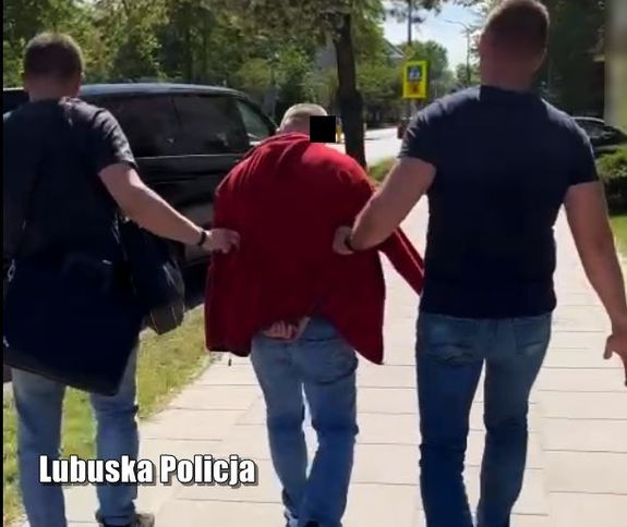 Policjanci prowadzą zatrzymanego