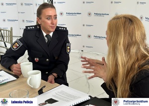 Policjantka z Niemiec rozmawia z druga kobietą podczas przerwy na konferencji.