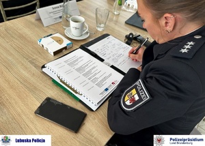 Policjantka sporządza notatki z konferencji.