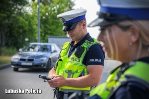policjantka kontroluje dane kierowcy