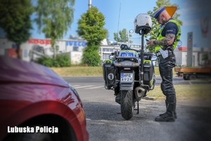 policjant stoi przy motocyklu