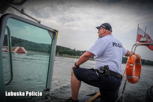 Policjant patrolu wodnego na łodzi obserwuje zachowania wypoczywających
