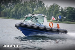 Policjant patrolu wodnego na łodzi monitoruje stan bezpieczeństwa