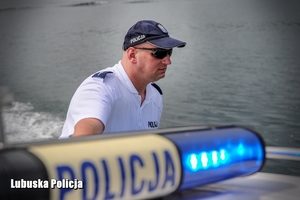 Policjant patrolu wodnego na łodzi obserwuje zachowania wypoczywających