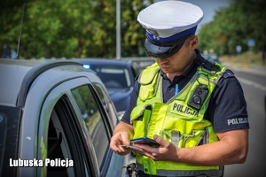 Policjant sprawdzający dokumenty kierowcy