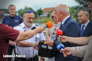 Wojewoda Lubuski przekazuje mężczyźnie defibrylator podczas konferencji prasowej.