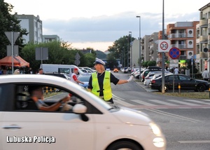 Policjantka drogówki kieruje ruchem na skrzyżowaniu.