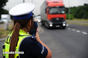 Policjantka kontroluje prędkość jadącej ciężarówki.