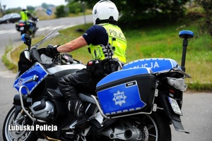 Policjant jadący na motocyklu.