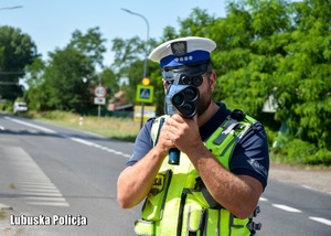 Policjant kontroluje prędkość jadących pojazdów.