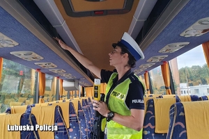 policjantka kontroluje wyposażenie autokaru