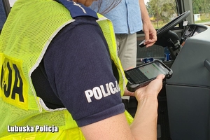 policjantka kontroluje dane kierowcy autokaru