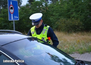 Policjant drogówki podczas kontroli trzeźwości kierującego pojazdem.