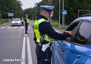 Policjant drogówki podczas kontroli trzeźwości kierującego pojazdem.