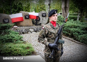 Żołnierz stoi przed Pomnikiem Pamięci Armii Krajowej.