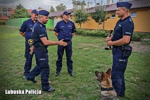 Gratulacje od policjantów dla wyróżnionego przewodnika psa służbowego.