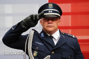 Policjant na tle flagi Polski.