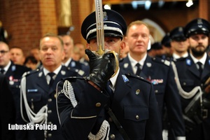 Dowódca kompanii honorowej Policji, a za nim pozostali policjanci stojący w kościele podczas mszy świętej.
