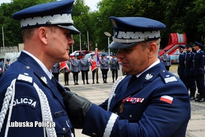 Komendant Główny Policji przypina odznaczenie Komendantowi Wojewódzkiemu Policji.