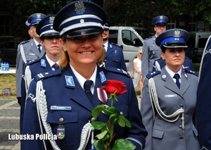 Policjantka pozuje do zdjęcia z różą.