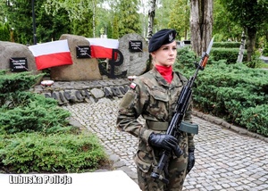 Żołnierz pełniąca wartę honorową przed pomnikiem.