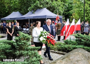 Wojewoda Lubuski wraz z towarzyszącą mu kobietą składa kwiaty przed pomnikiem.