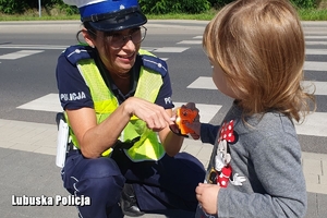 policjantka wręcza odblask dziecku