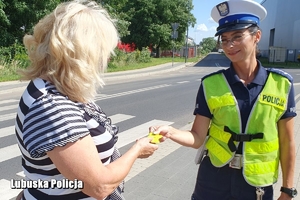 policjantka wręcza odblask kobiecie
