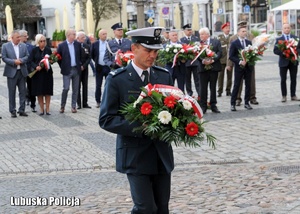 Funkcjonariusz Inspekcji Transportu Drogowego składa kwiaty przed Białym Krzyżem &quot;Solidarności&quot;.