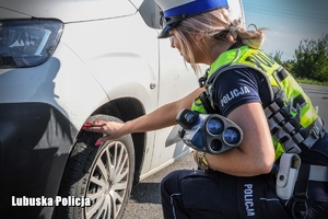 policjantka kontroluje ogumienie pojazdu