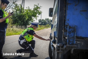 policjantka kontroluje ogumienie pojazdu