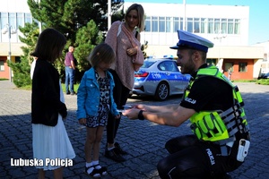 policjant rozdaje odblaski dzieciom