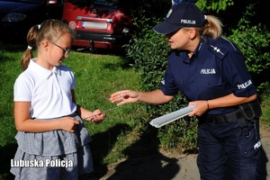 policjantka rozdaje odblaski dzieciom