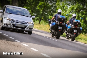 Policyjni motocykliści i samochód