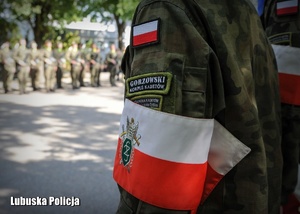 Biało - czerwona opaska na ramieniu żołnierza.