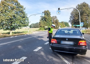 Policjant podczas kontroli drogowej kierującego pojazdem osobowym.