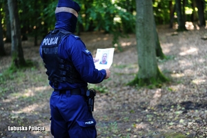 policjant podczas poszukiwań w lesie