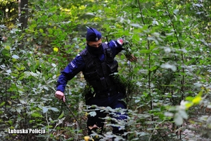 policjant podczas poszukiwań w lesie